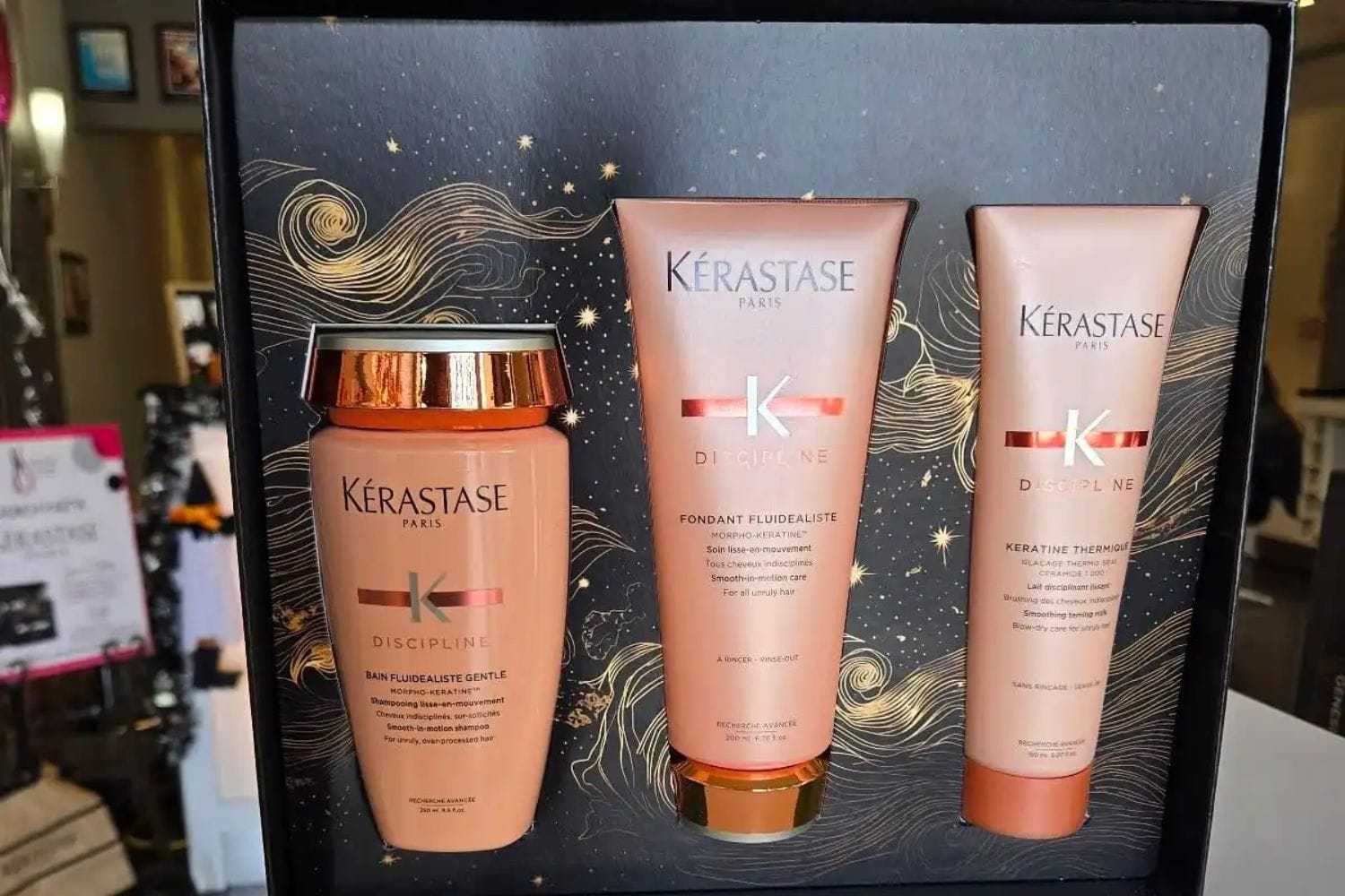 Kérastase hair care gift set with shampoo, conditioner, and treatment in an elegant box.